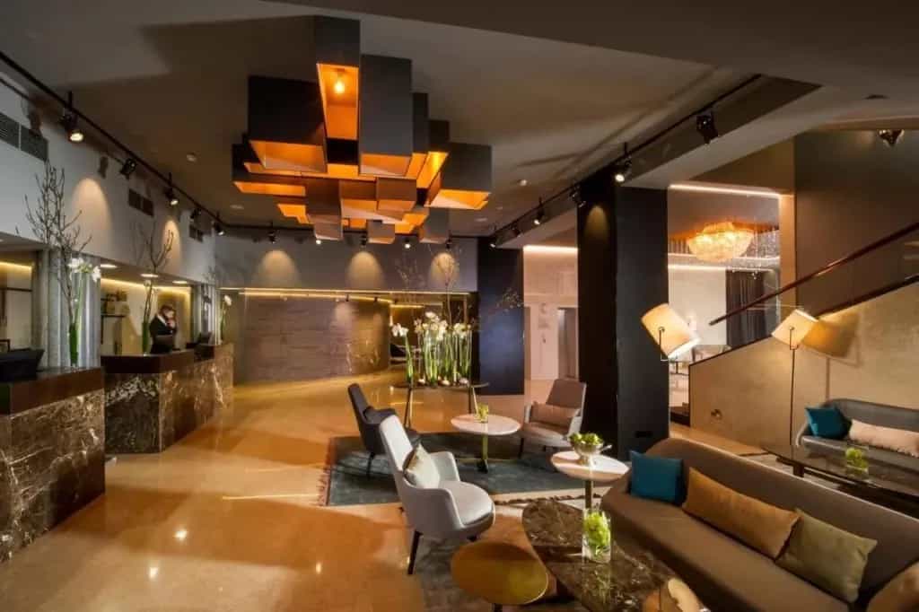 Hotel Slon lobby with marble reception desks, modern lighting, and contemporary seating area.