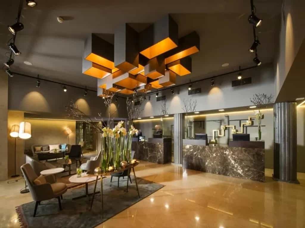 Hotel Slon reception area with modern lighting, marble desks, and seating area.