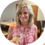 Woman smiling while holding a martini glass with olives indoors