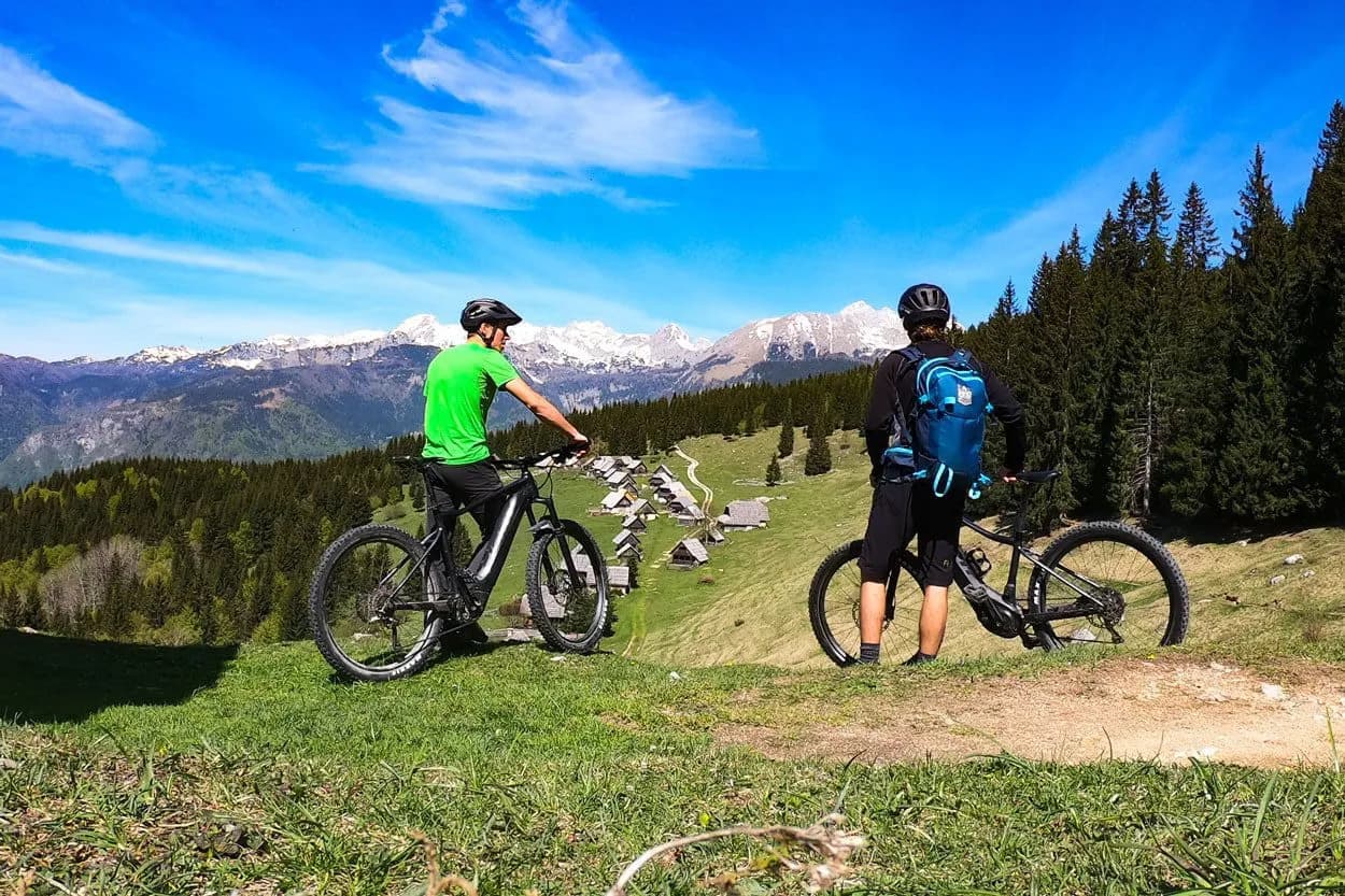 Mountain biking above Zajamniki Pokljuka with snow-capped Julian Alps in background