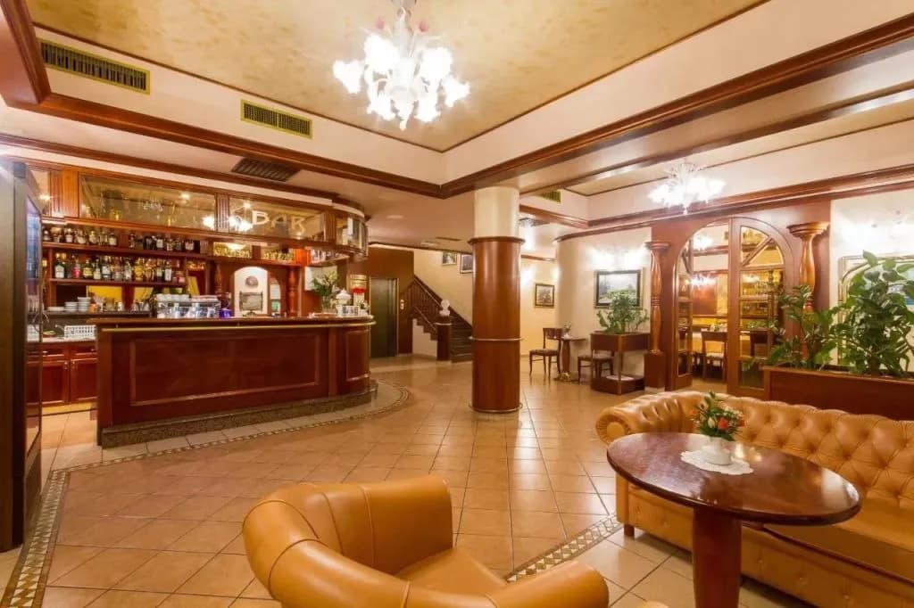 Hotel Marko lobby interior with a wooden bar, leather seating, and tiled floor.