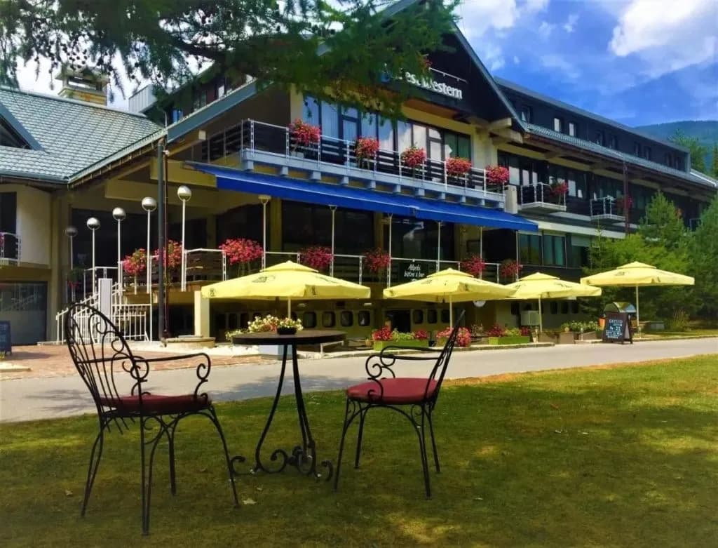 Outdoor seating area with wrought iron chairs before the Best Western hotel in Kranjska Gora.