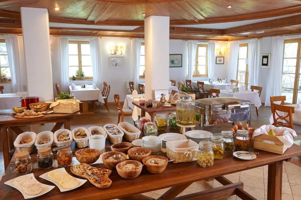 Hotel Plesnik breakfast buffet with cereals, fruit, and pastries in a bright dining room.