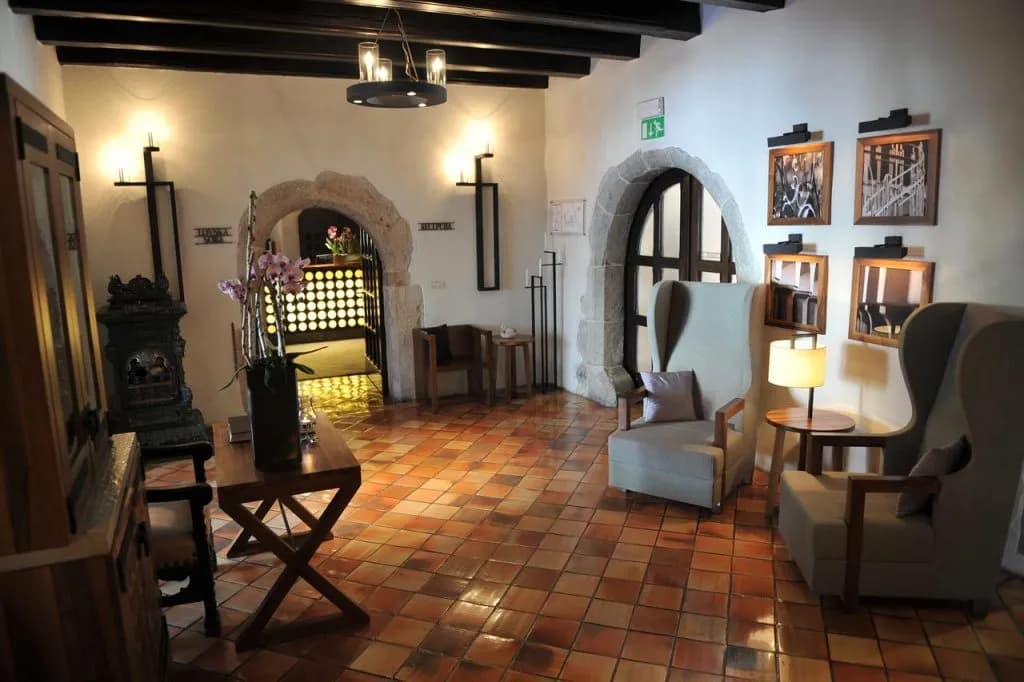 Hotel Grad Otočec lobby with stone arches, terracotta floors, and high-backed chairs.