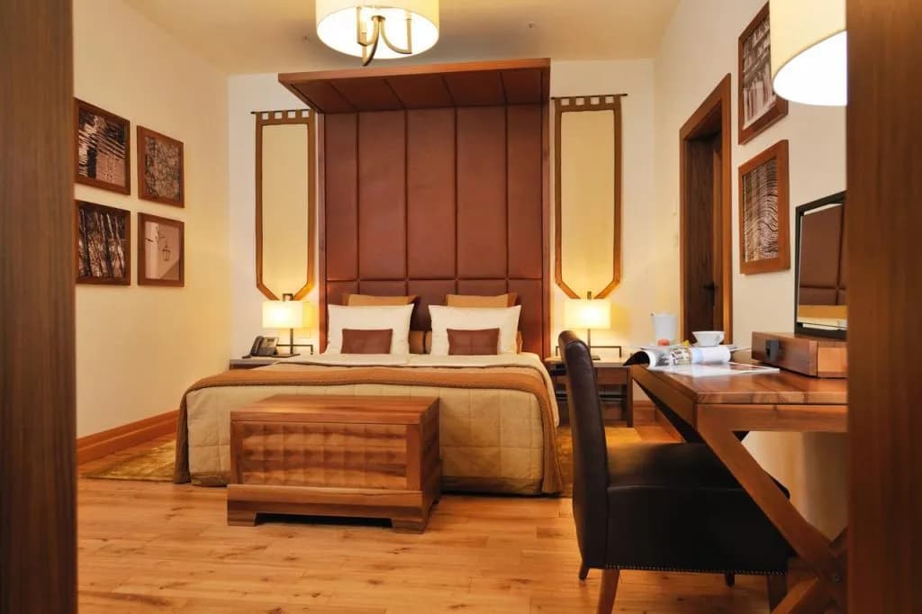 Hotel Grad Otocec room with large bed, wood furniture, and warm lighting
