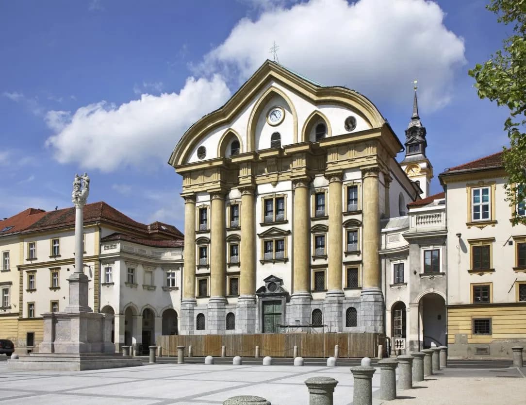 Franciscan Church of the Annunciation and monument on a sunny square in Ljubljana.