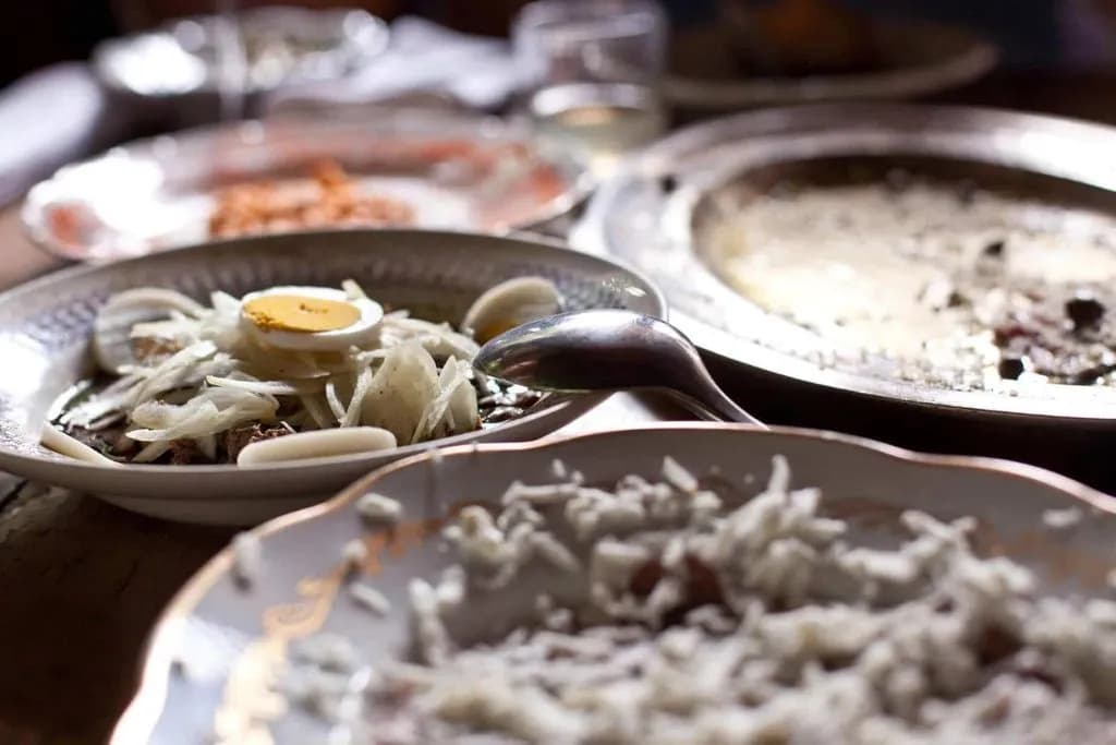 Plates of leftover food, including rice and a dish topped with sliced onion and hard-boiled egg.