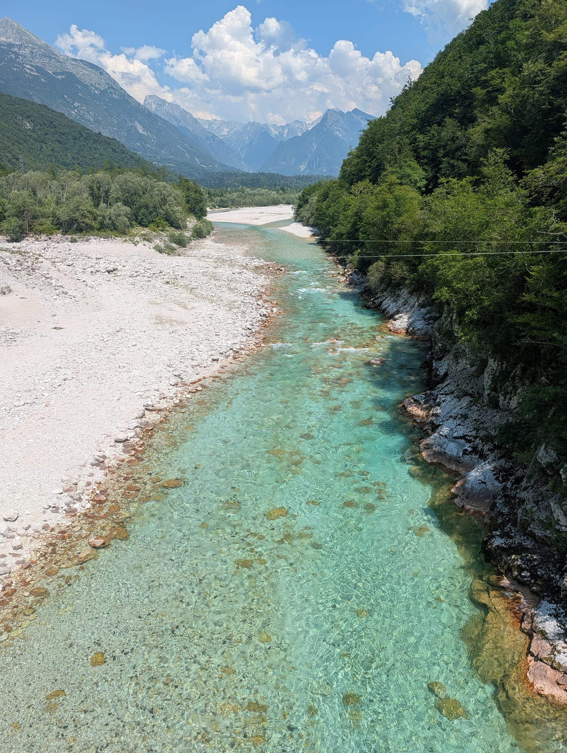 Emerald Soca River flowing through a rocky alpine valley with mountains