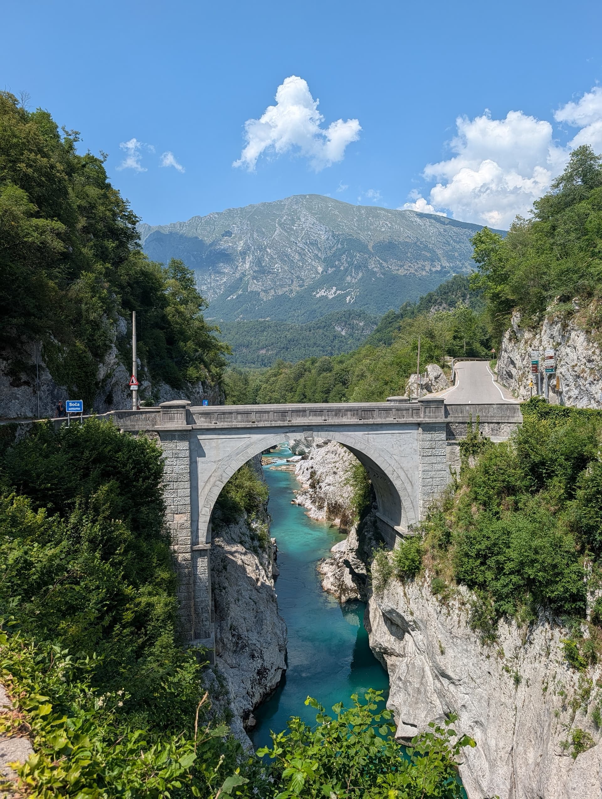 Napoleon Bridge over turquoise Soca River near Kobarid with mountains and forest