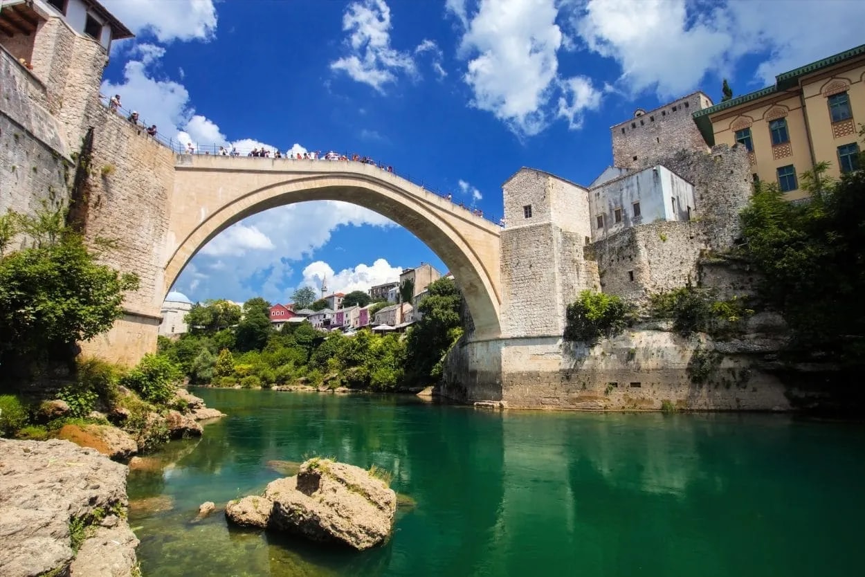 Stari Most bridge over emerald river with people on top, Mostar, Bosnia and Herzegovina