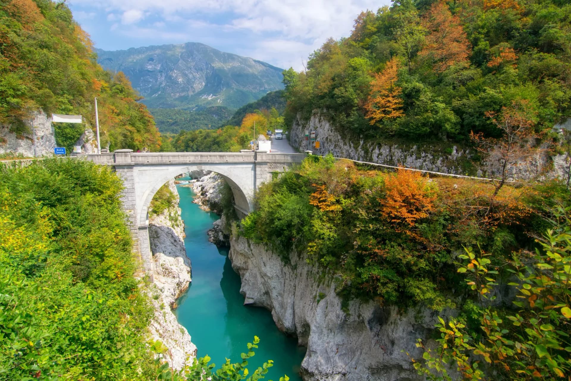 Napoleon's Bridge near Kobarid over turquoise river in gorge with autumn foliage.