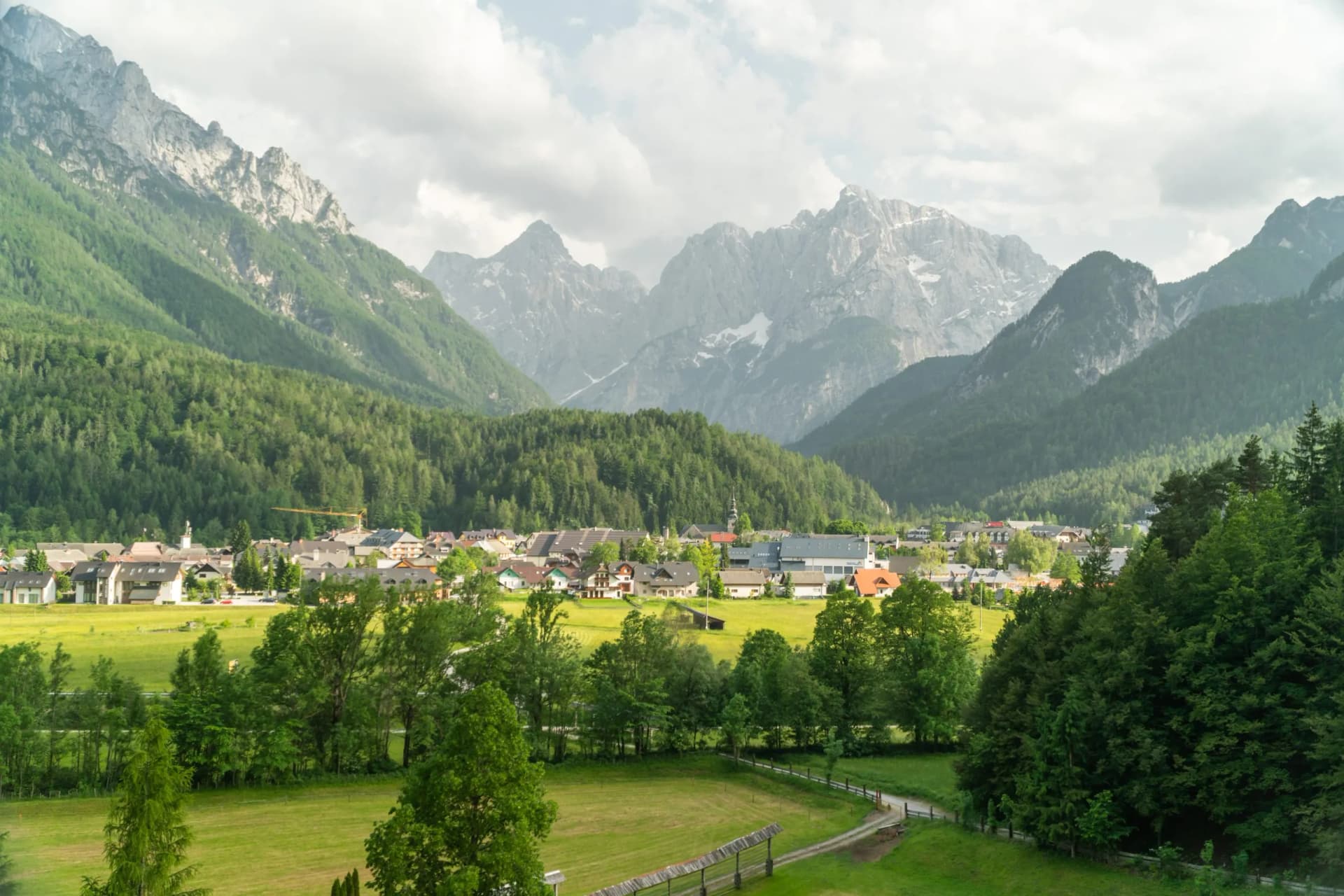 Mountain landscape view of Kranjska Gora village nestled in a green valley in Slovenia.