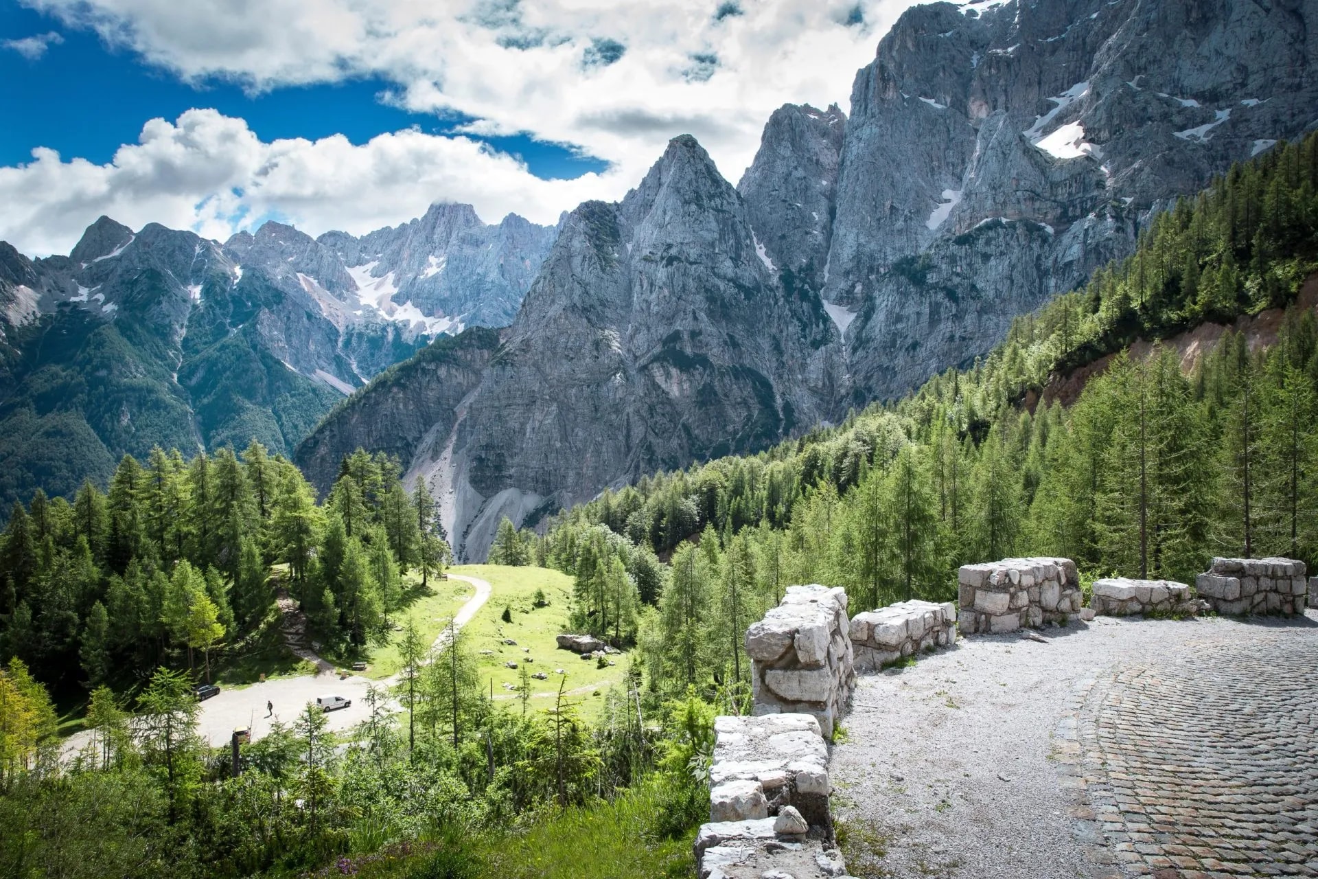 View from the road to Vršič Pass in Julian Alps, Slovenia, with rocky peaks and green forest.