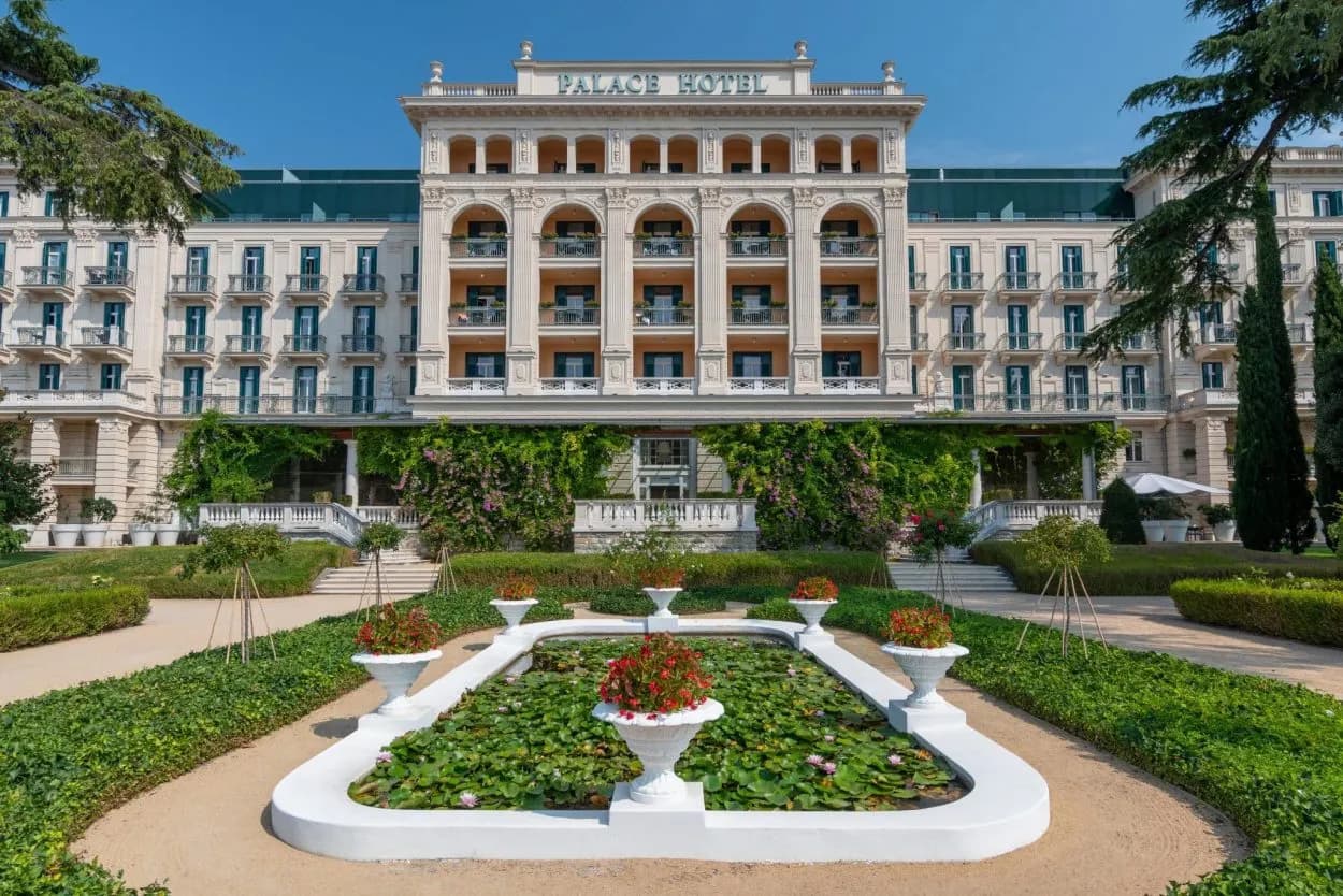Palace Hotel Portorož exterior with formal garden and lily pond under blue sky