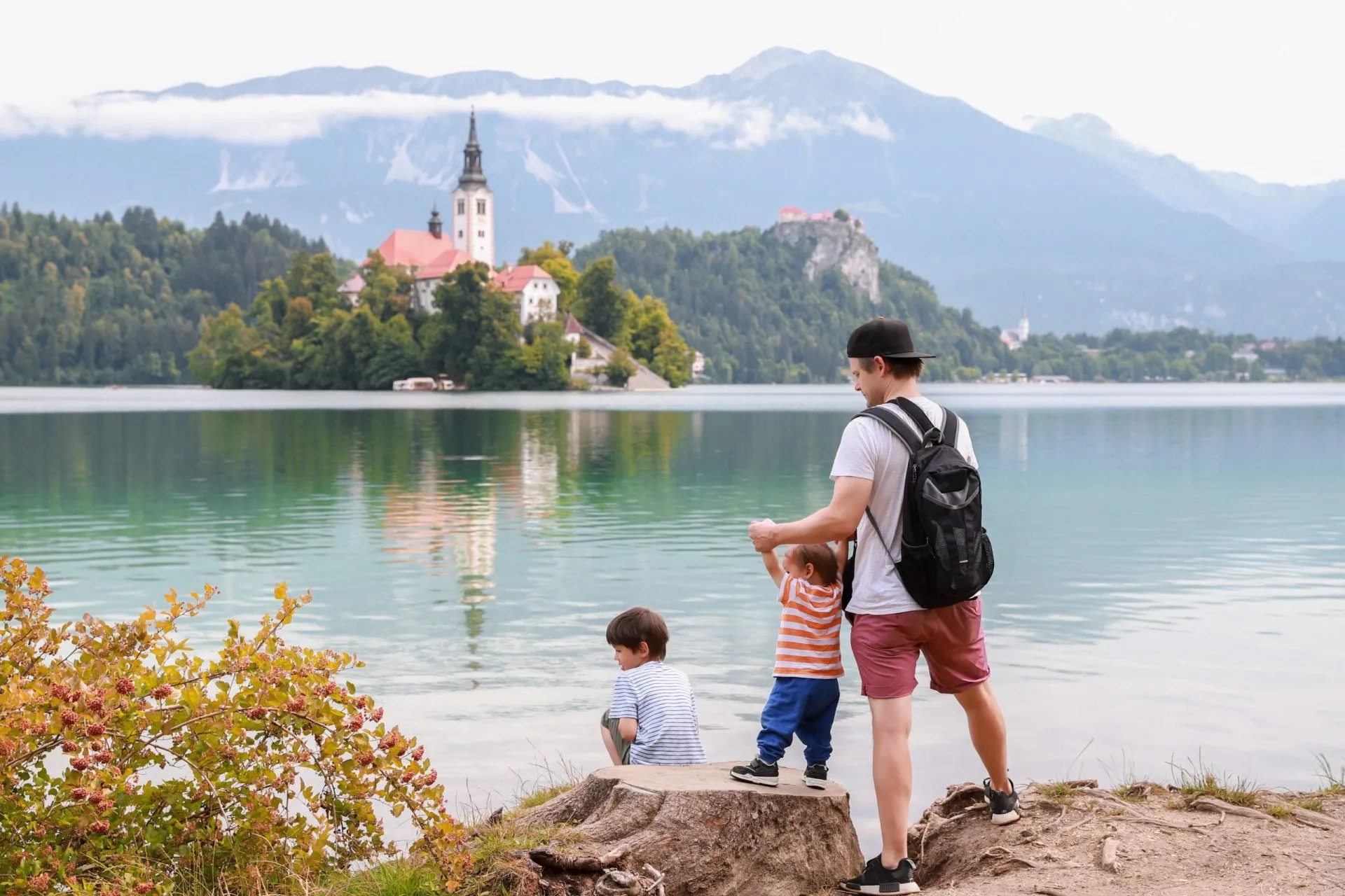 Father and sons by Lake Bled with island church and Julian Alps in background