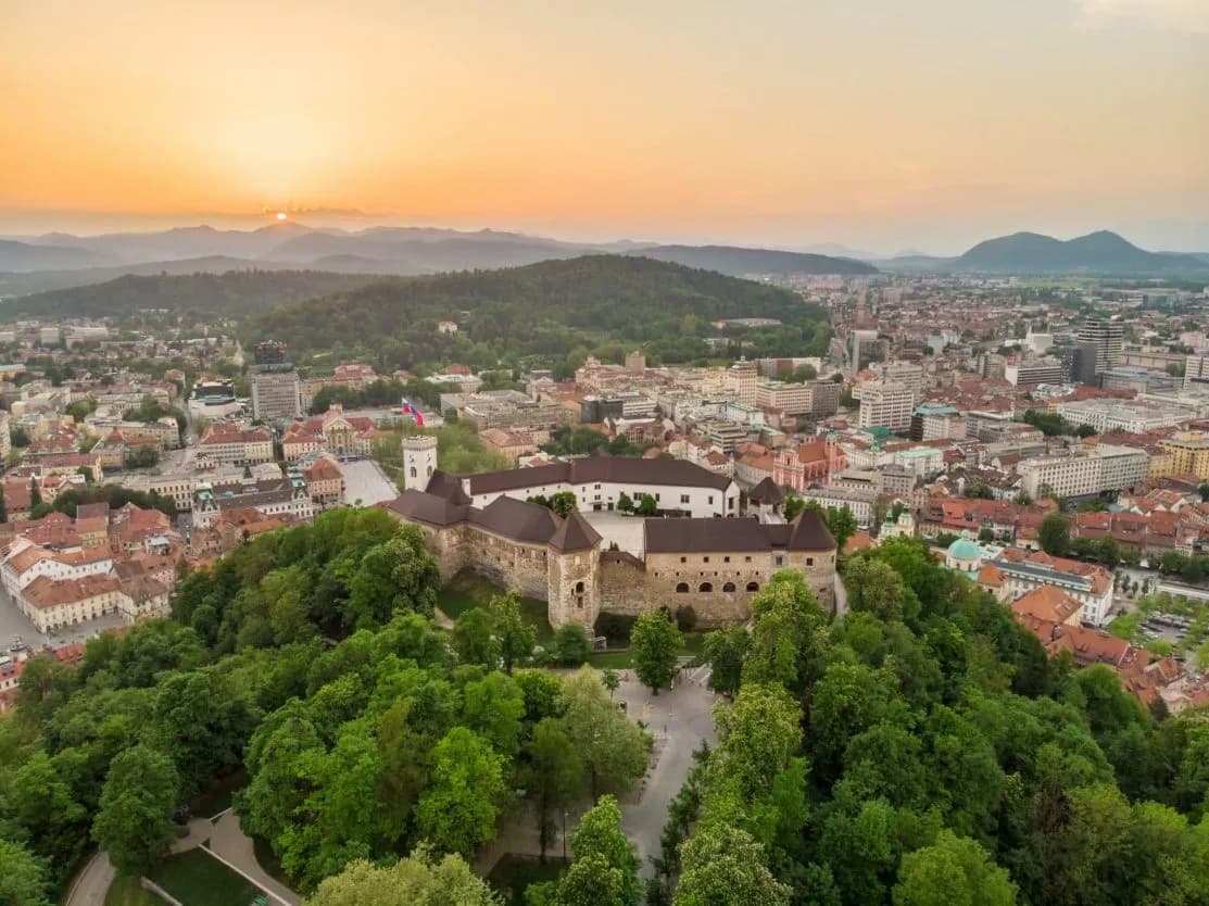 Ljubljana Castle overlooking the city and surrounding hills at sunset