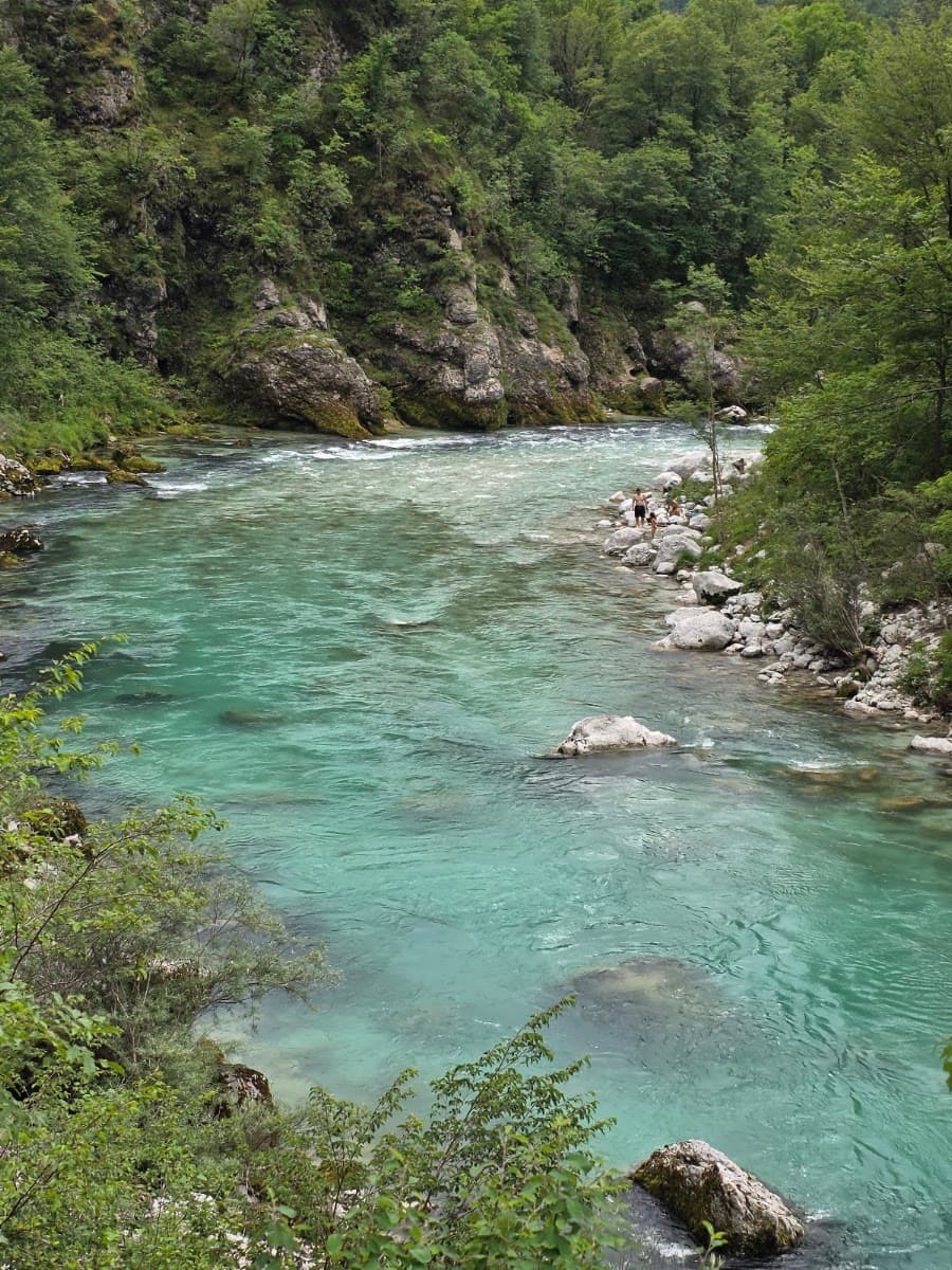 Turquoise river flowing through a rocky, forested canyon valley