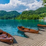 una vista más allá de los barcos a lo largo de la orilla del lago bled en bled escalada